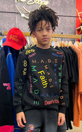Young person wearing a black sweatshirt with colorful text in a clothing store